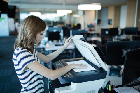 Side view of businesswoman using copy machine in office